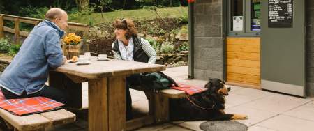 Couple enjoying coffee with pet dog