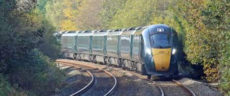 great western railway train on tracks in between trees