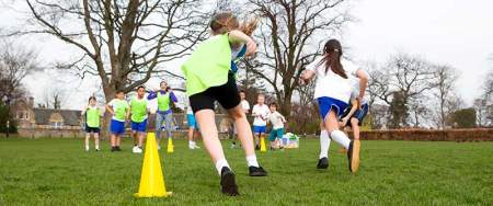 children running sports drills in a park