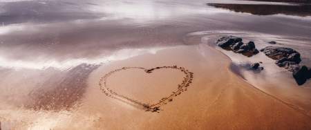 Heart drawn into sand on a beach
