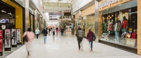 people shopping and walking past shop windows in Swansea Quadrant