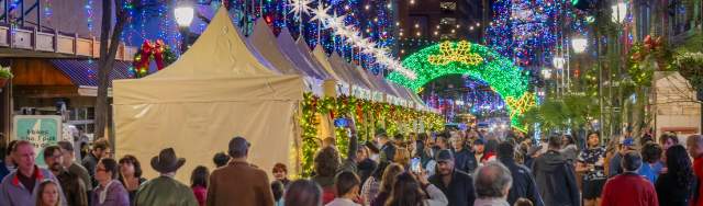 Festive holiday lights above outdoor market