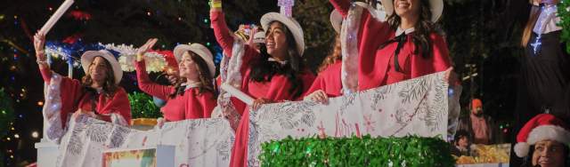 people waving on barge to guests at ford holiday river parade