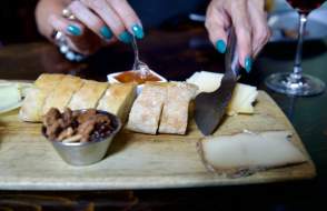 Charcuterie board with bread, nuts, cheese and preserves