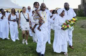 Group of African Americans holding flowers and marching in procession