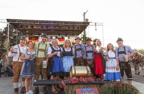 Row of people in German garb smiling for the camera at Saline Oktoberfest