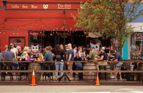 People dining outdoors at The Owl in Milan, MI