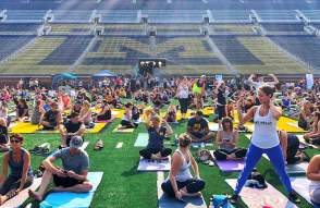 People doing yoga on the football field at Michigan Stadium
