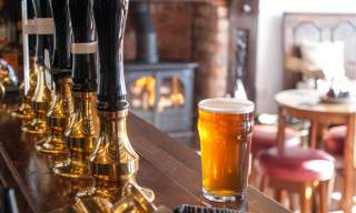 A pint of beer on a bar in a cosy pub