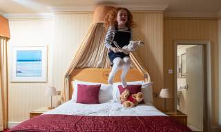 Young girl jumping on the bed