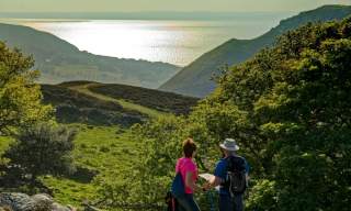View of two walkers looking out over Sychnant Pass