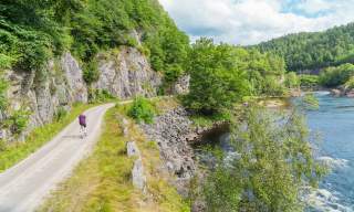 Woman biking along the river