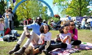 Family sitting in the grass at the Cheltenham Jazz Festival, Imperial Gardens.