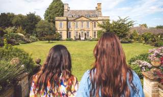 Two women looking across the lawn towards Bourton House