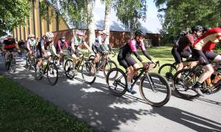 En gruppe syklister i et sykkelritt som sykler på en grusvei.