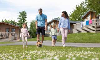 family outside a tent enjoying firepit