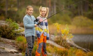 Two girls fishing by the lake