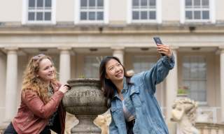 Visitors enjoying Cheltenham, taking a selfie near Neptune Fountain
