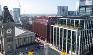 A view from high up looking down over Paradise in Birmingham. Cranes in the background work on construction projects within the city.