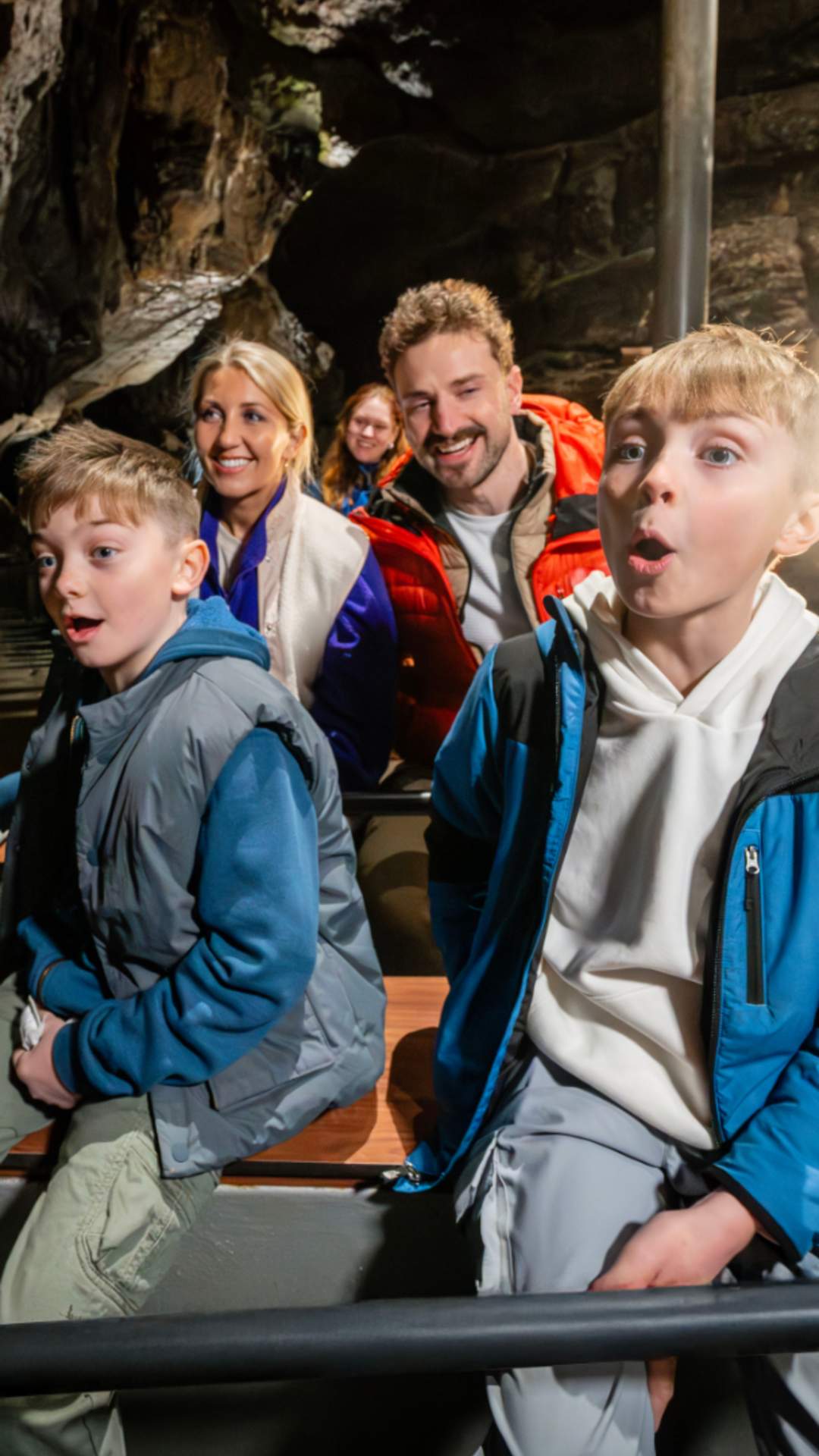 Visitors travelling by boat through the Marble Arch Caves, surrounded by towering limestone formations deep beneath the Fermanagh countryside.