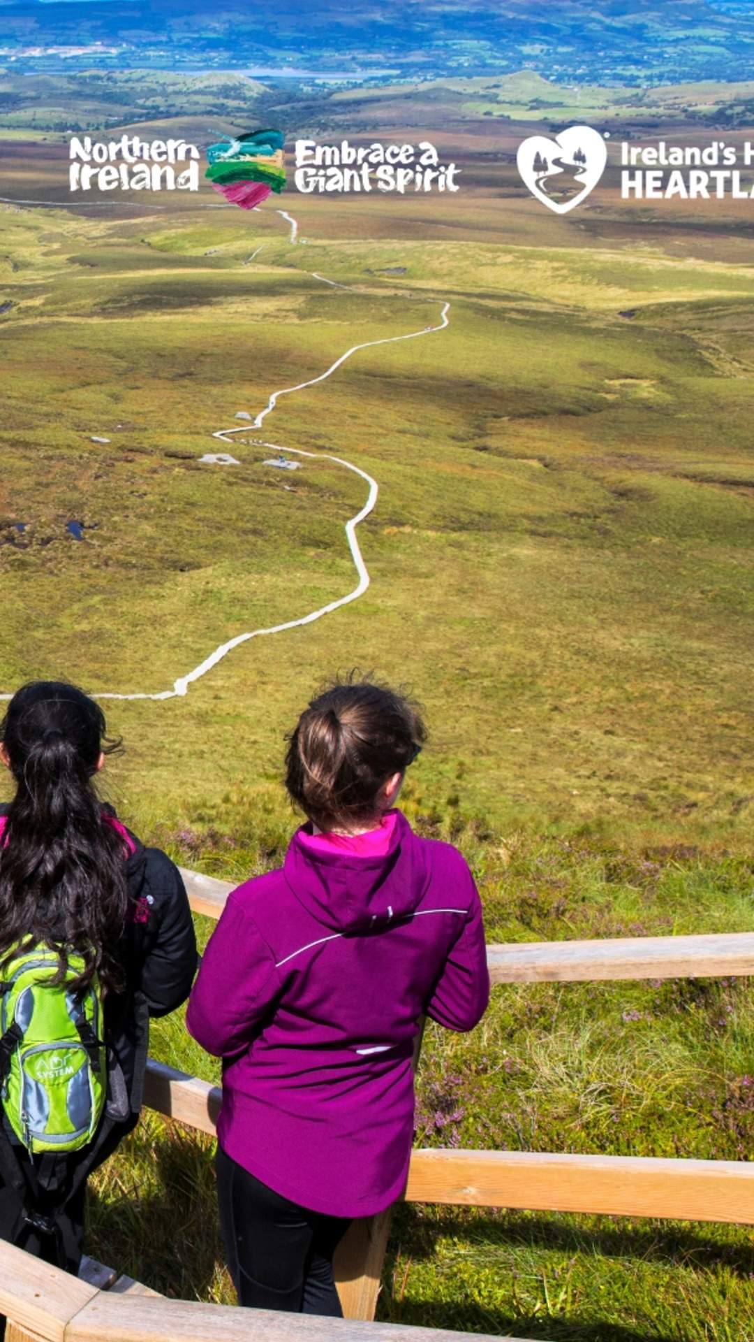 Group of walkers looking out over the landscape from the boardwalk at Cuilcagh Mountain.