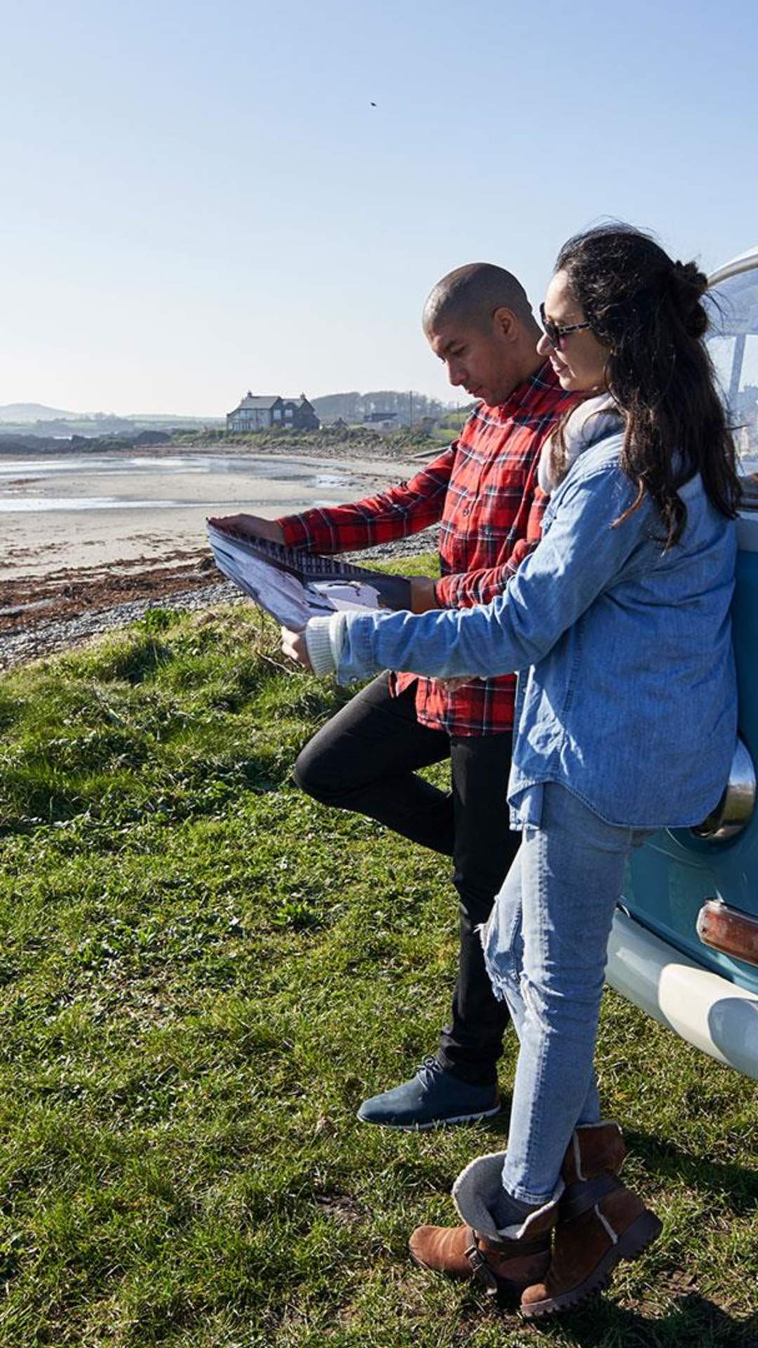 A couple look at a map while parked up overlooking Strangford Lough