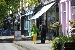 Shoppers in Montpellier District Cheltenham, walking past row of shops.