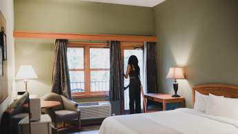A person looking out their window in a hotel room.