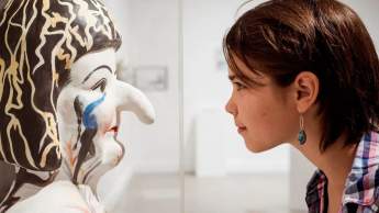 A girl looking at a statue.