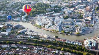 An aerial view of hot air balloons flying over Bristol Harbourside