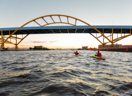 two kayakers kayaking under the Hoan Bridge