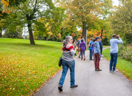 a woman with binoculars birding in a park