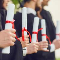 Students holding diplomas after graduating college.