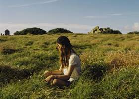 Girl sitting on grass in Autumn