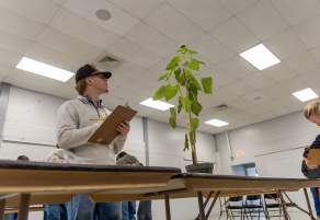Guy looking at plant at Farm Show 2026 at Tony's Pizza Event Center in Salina, Kansas
