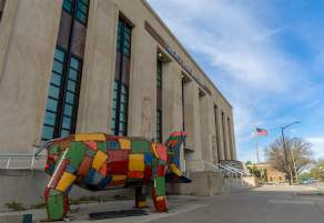 a front view of the Smoky Hill Museum with a colorful statue of a hippo titled "Patches" in front