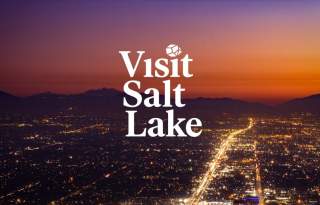 Sunset overhead view of the Salt Lake Skyline with the words Visit Salt Lake and Meeting Planner's Guide Book