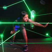Young Girl Tries to Make Her Way Through the Green Pointed Lasers