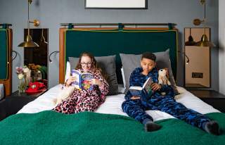 2 children reading in hotel bedroom
