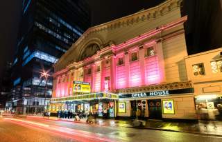 Exterior of Manchester Opera House at night with pink lighting