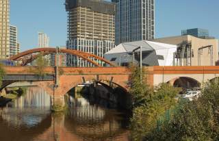 River and bridge in a city with Aviva Studios in the background