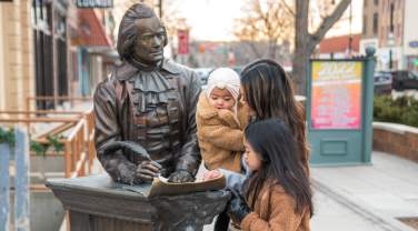 family all looking at the thomas jefferson statue in the city of presidents walking tour in downtown rapid city, sd