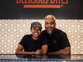 Delicious Bites Owners smiling behind treat counter