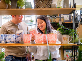 couple looking at colorful plant pots