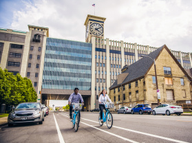 two people using bublr bikes, biking under the clocktower