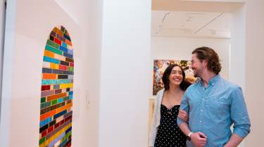 A couple smile at each other in front of artwork at the Nerman Museum of Contemporary Art in Overland Park.