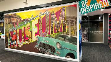 Wall decorated like a postcard saying "Greetings from the Johnson County Museum"