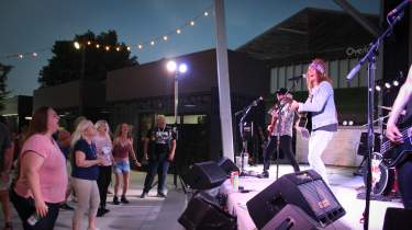 A band performs on stage at SERV during an evening concert.