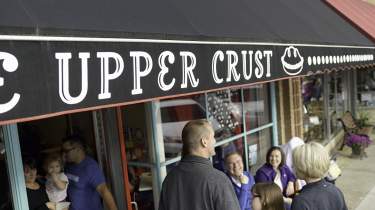 People socializing on the charming streets of Downtown Overland Park at The Upper Crust Pie Shop and Bakery