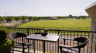 A dining table with soccer fields in the background